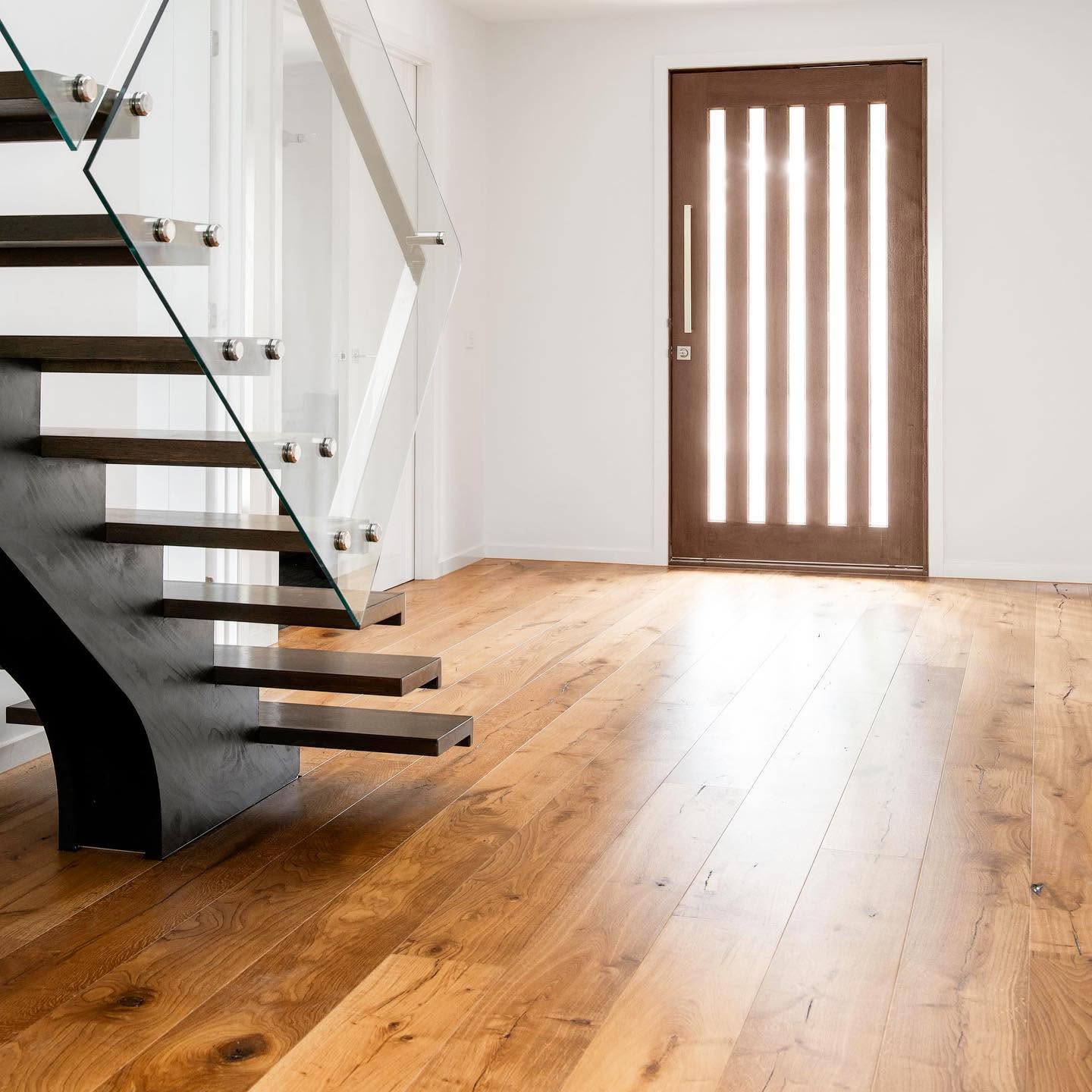 Rustic wide board oak in an entry with a floating staircase