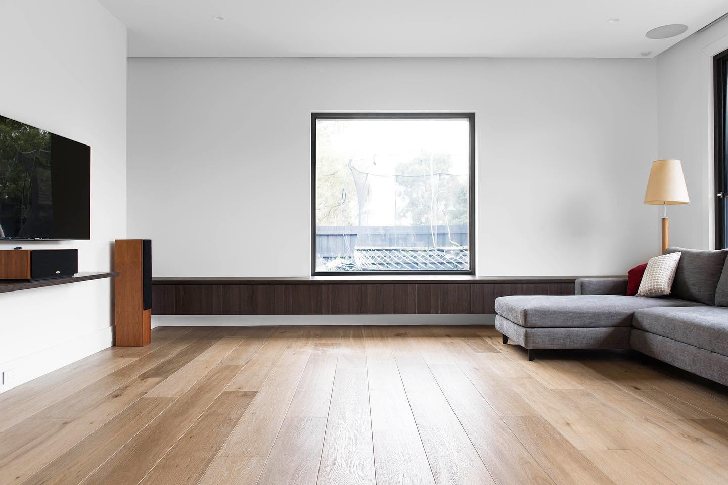 Wide board oak floor running through a light filled living room